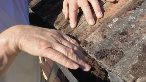 Man removing moss from house gutter. Stock Footage 95628502