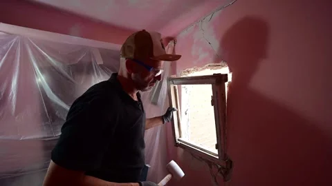 Man removing an old window frame during house demolition Stock Footage 347640736