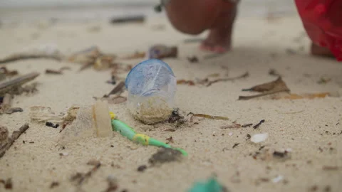 Man removing a plastic bottle from a pristine sandy beach Vidéo 343572646