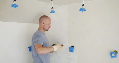Man renovating and applying plaster on old wall. Repairing old walls with Stock Footage 246554346
