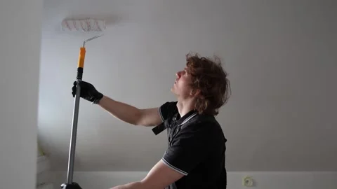 Man repainting attic apartment Stock Footage 335045402