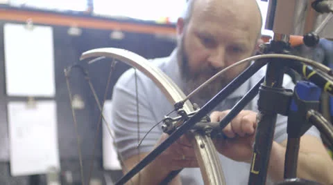 Man repairing bicycle in workshop Stock Footage 24570169