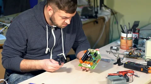 Man repairing broken device in workshop Видео 68850096