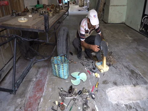 Man is repairing a broken ventilator in the workshop Stock Footage 71036724