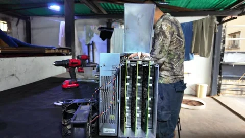 Man repairing a cryptocurrency mining rig in a professional hardware workshop Stock Footage 327278373