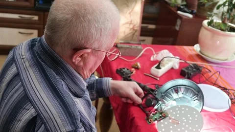 Man Repairing Electronic Device, Concentrated Elderly DIY Hobbyist Fixing Vídeos de archivo 342230967