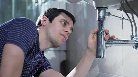 Man repairing a leaking pipe Stock Footage 148543801
