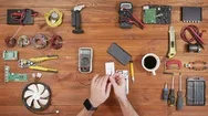 Man Repairing A Mobile Phone. Checks Parts Inside The Device. Wooden Table Top Stock Footage