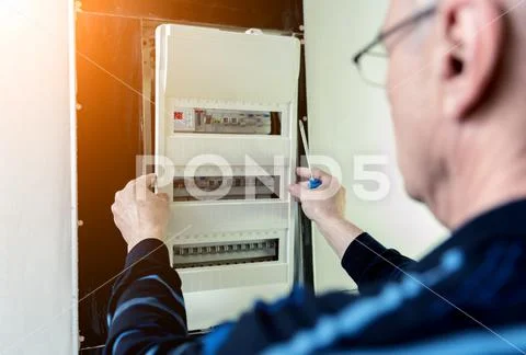 The man is repairing the switchboard voltage with automatic switches ...