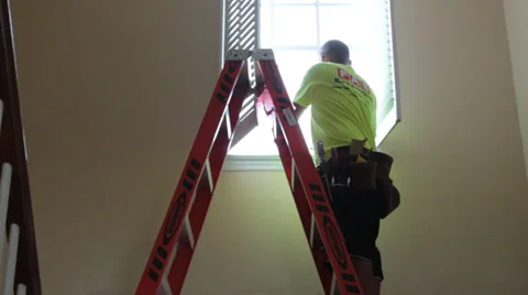 Man repairing window opens shade in upper story house foyer Stock Footage 37249818