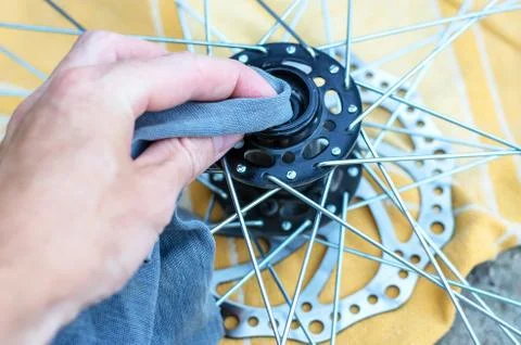 A man repairs a bicycle wheel. Replacement of bearings on the front wheel. Stock Photos