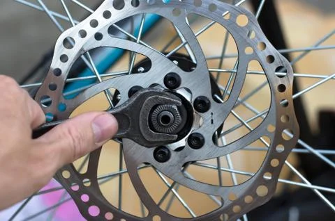 A man repairs a bicycle wheel. Replacement of bearings on the front wheel. Stock Photos