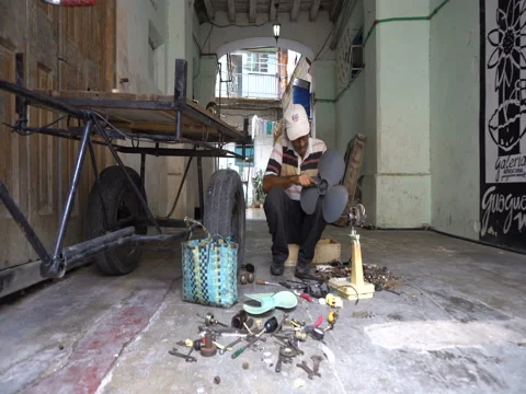 Man repairs a broken ventilator in the workshop at Havana Stock Footage 71036260