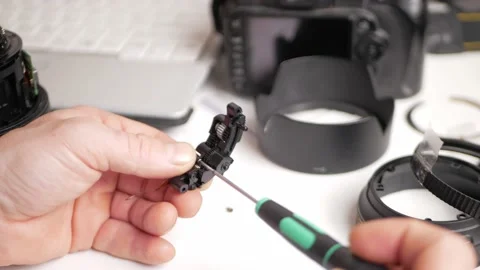 Man repairs camera lens, autofocus motor, tools. screwdriver, bolts, composite Stock Footage 168375648