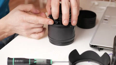 Man repairs camera lens, autofocus motor, tools. Workshop, master Stock Footage 168375725