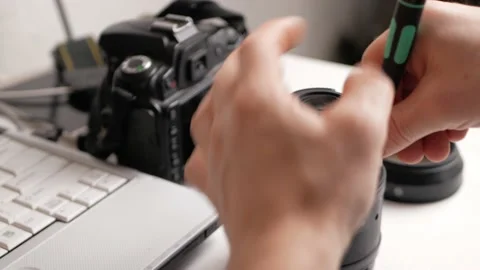 Man repairs camera lens, autofocus motor, tools. workplace Stock Footage 168375755