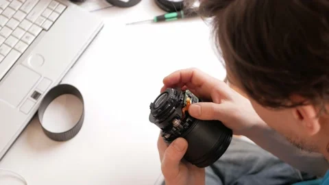 Man repairs camera lens, autofocus motor, tools. master thinks Video stock 168375774