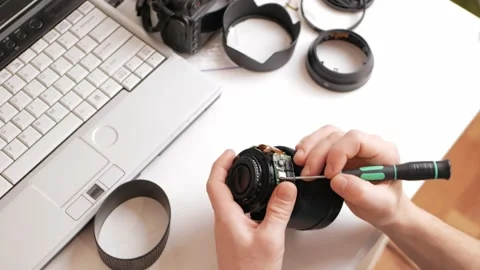 Man repairs camera lens, autofocus motor, tools. professional repair Stock Footage 168375788