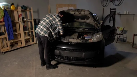 A man repairs a car in a garage Stock Footage 127437587