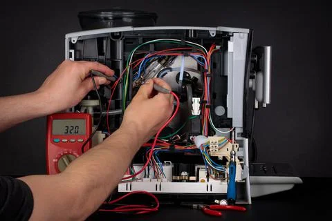 A man repairs the coffee machine that is damaged. Inside the coffee machine.  Stock Photos