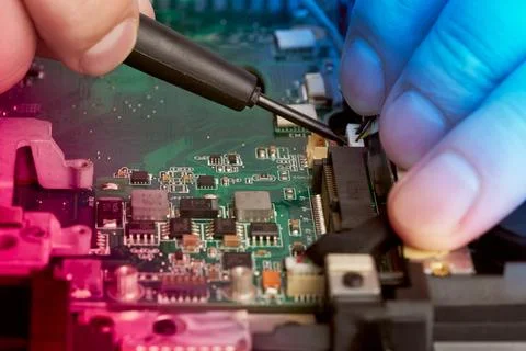 Man repairs computer. A service engineer in shirt repairs laptop, Stock Photos