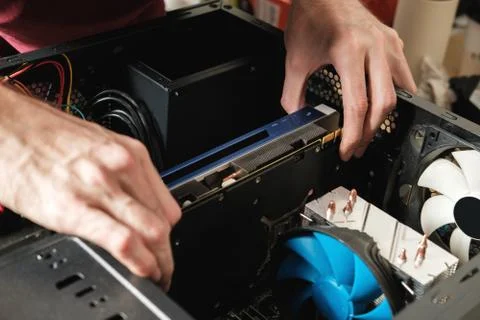 Man repairs a computer system unit, changes parts, video card and hard drive Stock Photos