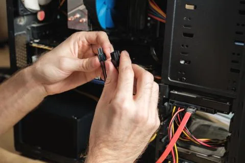 Man repairs a computer system unit, changes parts, video card and hard drive Stock-Fotos