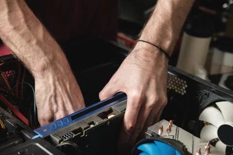 Man repairs a computer system unit, changes parts, video card and hard drive Stock Photos