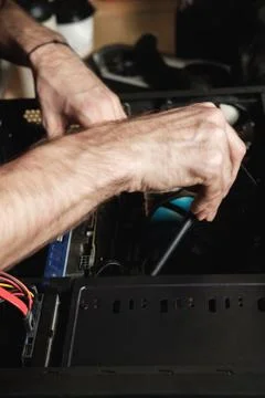 Man repairs a computer system unit, changes parts, video card and hard drive Stock Photos
