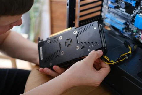 Man repairs a computer system unit, changes parts, video card and hard drive Stockfoto's