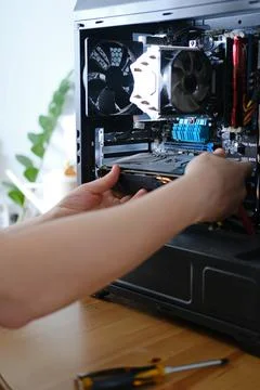 Man repairs a computer system unit, changes parts, video card and hard drive Stock Photos