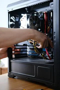 Man repairs a computer system unit, changes parts, video card and hard drive Stockfoto's