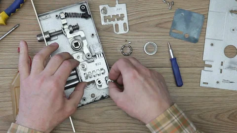 A man repairs a disassembled door lock f... | Stock Video | Pond5