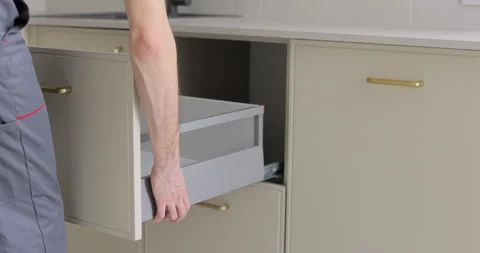 Man repairs a drawer in the kitchen, a man is assembling kitchen furniture Видео 329763547