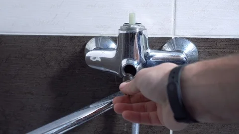 The man repairs the faucet in the bathroom, changes the axle, close-up Stock Footage 101301397
