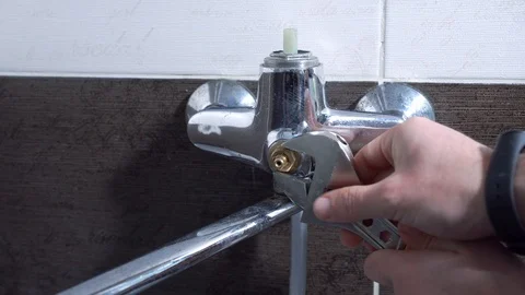 The man repairs the faucet in the bathroom, changes the axle, close-up Stock-Footage 101339854