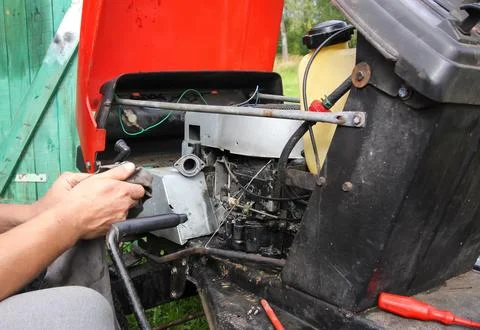 A man repairs a grass mower using hand tools. Practical maintenance and hom.. Stock Photos