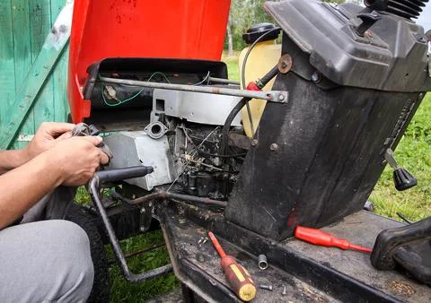 A man repairs a grass mower using hand tools. Practical maintenance and hom.. Stock Photos