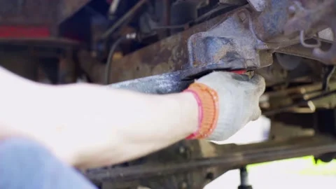 Man repairs an old car, changes shock absorbers, close-up, guy lies under a Stock Footage 136106265