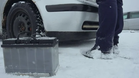 Man repairs or fixes broken car in winter snowfall. Malfunction or problem with Stock Footage 121137656