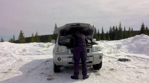 Man Repairs Or Fixes Broken Car In Winter Mountains Stock Footage 220735806