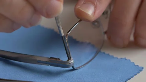 Man repairs a pair of glasses with a screwdriver. Close up. Vídeo Stock 149259158