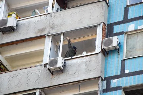 A man repairs a window after an explosion in the city of Dnepr in Ukraine, re Stock Photos