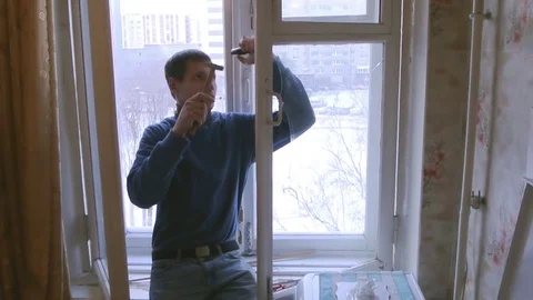 Man repairs wood window. Replace broken glass on window Stock Footage 83267152