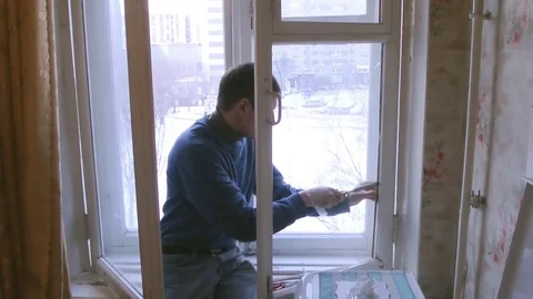 Man repairs wood window. Replace broken glass on window Stock Footage 83267541