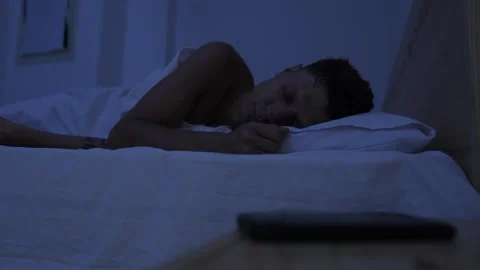Man repeatedly checking smartphone after trying to sleep, compulsive phone use Stock Footage 346252148