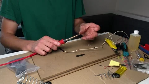 Man replacing the tip of a soldering iron during electronics work on a clut.. Stock Footage 318673420