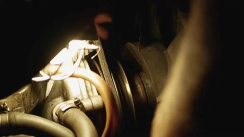 Man replases engine belt in old classic car at nighr under lamp light Video stock 131406319