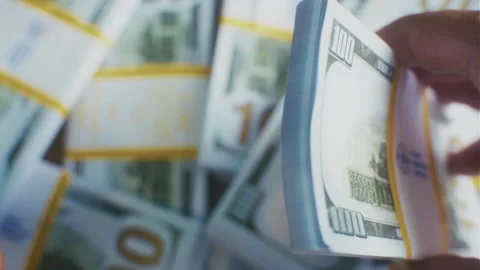 A man is rereading a stack of hundred dollar bills Stock Footage 314381571