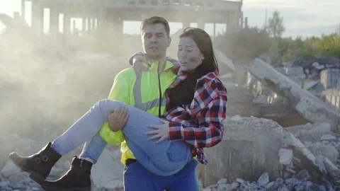 Man rescue worker in a uniform is on the hands of the earthquake victim slow mo Stock Footage 114830800